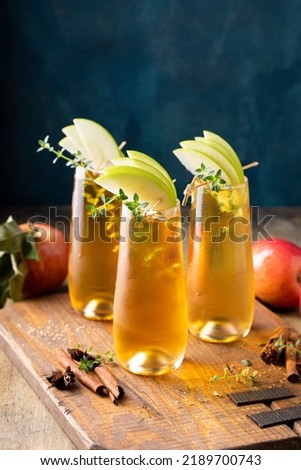 Apple cider mimosa for fall brunch, garnished with apple slices, autumn cocktail or mocktail idea
