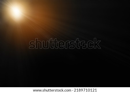 Abstract sun flare over black background. lens flare effect Golden sun light.
 Royalty-Free Stock Photo #2189710121