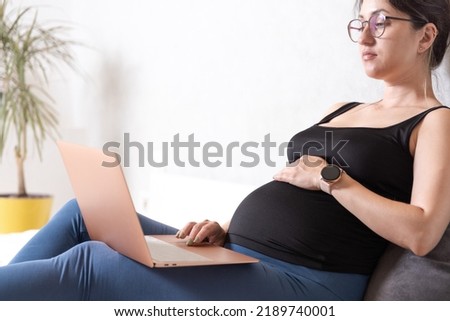 A woman during pregnancy works remotely from home using a laptop. High quality photo