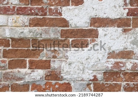 Old brown stone brick with peeling white paint wall texture for background, pattern. High quality photo