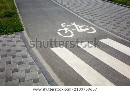 paved bike path with markings for traffic next to the pedestrian path