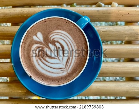 This is a picture of Latte Art on top of Hot Chocolate. Latte art is the design you see on top of (typically) drinks like lattes, chocolate, cappuccinos, and similar milk-and-espresso beverages.
