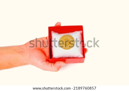 Man opens gift box containing bitcoin coin on white background