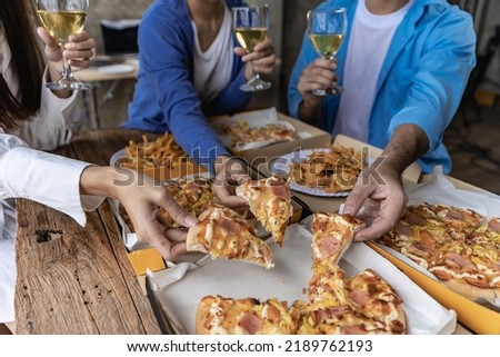 Group of male and female colleagues having pizza lunch together at the office after work celebration concept