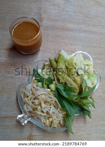 Pecel. In the form of several vegetables in the form of cabbage, sprouts, cucumber, turi flower and basil mixed with peanut sauce. Boiled vegetables are placed on a plate. Indonesian food.