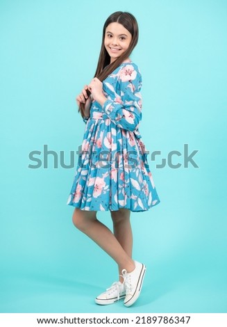 Happy teenager, positive and smiling emotions. Elegant teenager child girl in fashion summer dress. Girl dressed in cotton dress isolated on blue background.