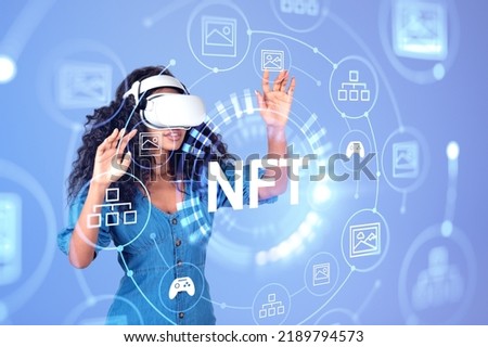 Black woman in vr glasses fingers touching NFT hud hologram with digital icons on purple background. Concept of virtual world and digital art
