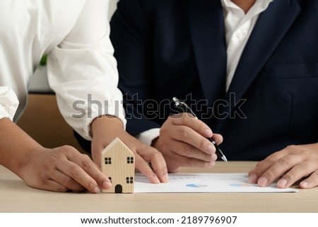 Businessman and woman to sell or buy house property as broker and client sign contract and payment before give house key to access building. Mortgage and other financial deal for home.