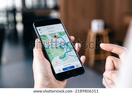 Hand of young woman searching location in map online on smartphone. Royalty-Free Stock Photo #2189806311
