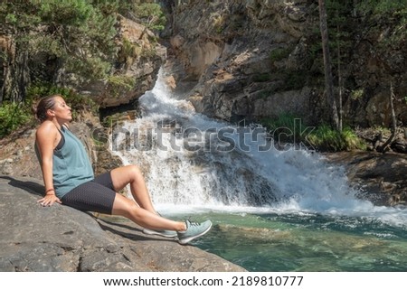woman relaxing in the nature on a waterfall background