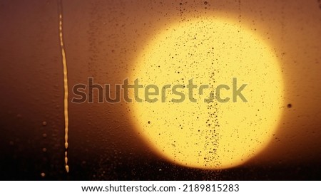 Water drops on window glass with sunset light, wide photo