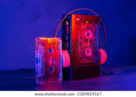 Vintage cassette tape player in neon light. 90s advertisement style. Disco party nostalgy concept Royalty-Free Stock Photo #2189824567