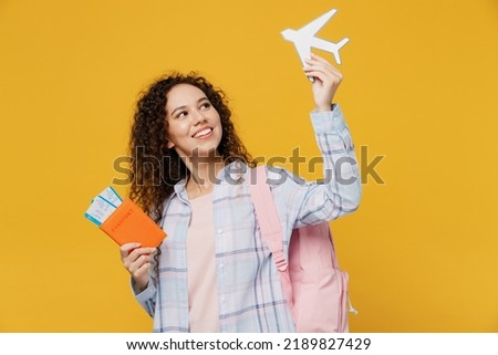 Traveler fun happy black teen girl student wear casual clothes hold passport tickets airplane isolated on plain yellow background. Tourist travel high school study abroad getaway. Air flight concept Royalty-Free Stock Photo #2189827429