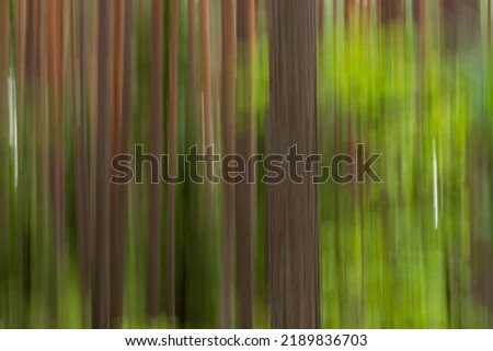 Green blurred background of summer forest. Vertical blur. Circle blur.