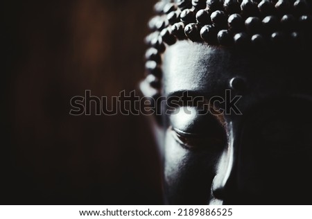 Meditating Buddha Statue on dark background.	Soft focus. Close up. Copy space.                                