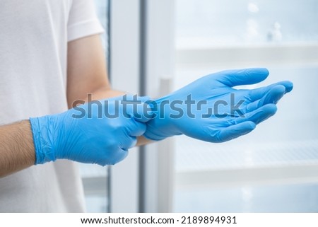 Doctor wearing blue nitrile gloves (select focus) Royalty-Free Stock Photo #2189894931