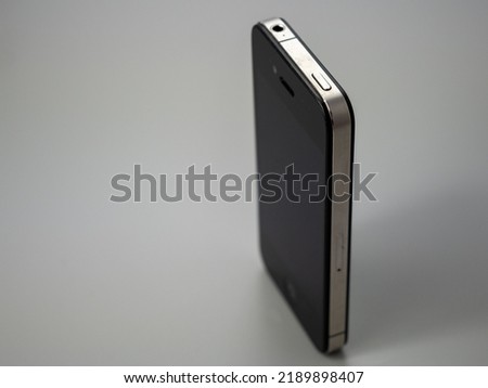 Old smartphone. Broken phone. Phone on a gray background. Broken smartphone.