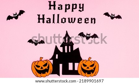 Happy Halloween pastel pink background with bats, pumpkins ahd horor house. Flat lay. Holidays concept