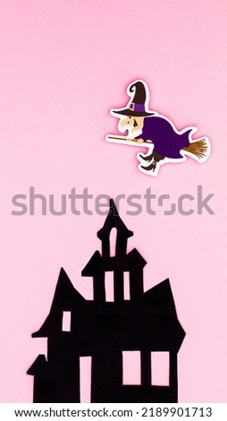 Creepy horor house with witch on pastel pink background. Flat lay. Creative Halloween concept