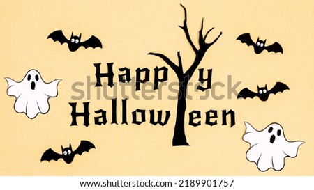 Happy Halloween beige background with text, scary tree, bats and ghosts. Flat lay. Creative concept
