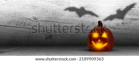 halloween pumpkin lantern with shadow of bats in a wooden rustic room, background concept with copy space for advertising