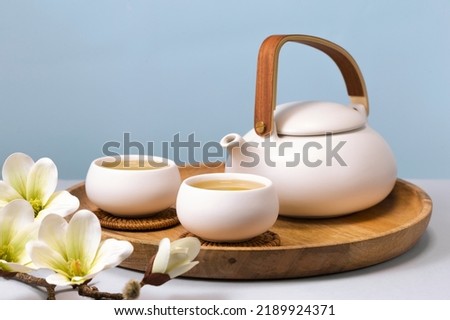 Herbal tea with two white tea cups and teapot. Tea concept Royalty-Free Stock Photo #2189924371