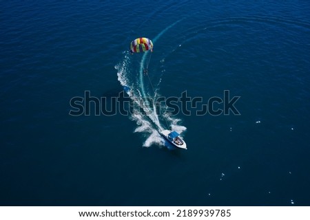 Drag Boat parasailing top view. The boat pulls a parachute with people. Royalty-Free Stock Photo #2189939785