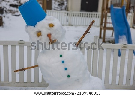 Close up view of unsteady funny snowman due to warm weather made by children in winter garden.  Sweden.
