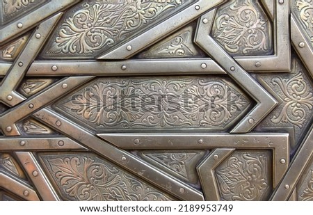 Detail of metal door with traditional islamic ornament. Copper window shutter with antique and national moroccan floral pattern. Oriental ornaments with artistic with chasing for brass Royalty-Free Stock Photo #2189953749