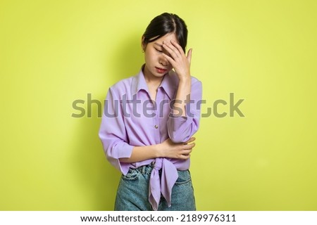 Female Depression. Unhappy Asian Lady Covering Face Crying And Feeling Sad Standing Posing Over Yellow Studio Background. Mental Health Problem And Frustration Concept