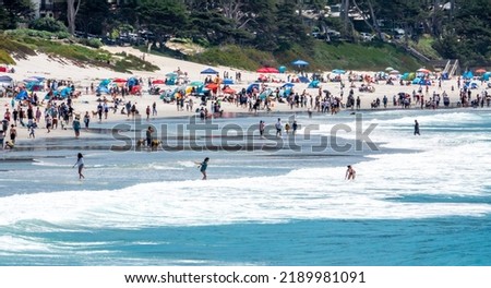 Large numbers of people enjoy the Pacific Coast of California at 
the dog friendly Carmel Beach, at Carmel by the Sea.  Royalty-Free Stock Photo #2189981091