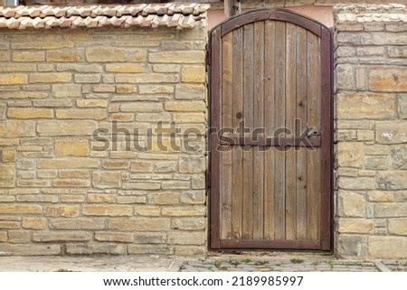 Wooden antique door in a stone wall. Place for an inscription. Copy Space