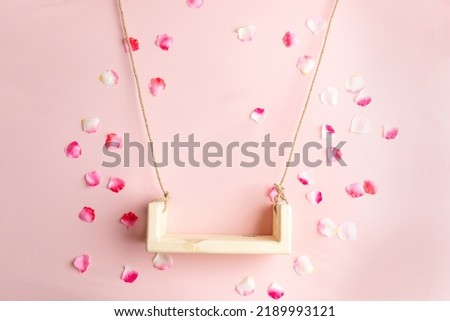 background texture empty space for baby. children's swing for a photo shoot of newborns. photo props. the bed is decorated with flowers. furniture for dolls and flying rose petals Royalty-Free Stock Photo #2189993121