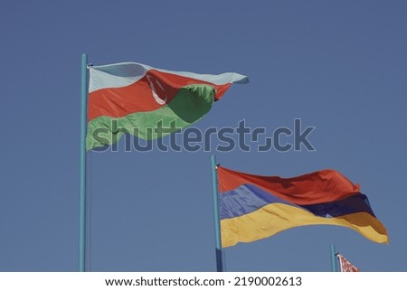 The national flags of Azerbaijan and Armenia are fluttering in the wind. State symbols