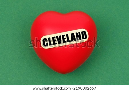 Love for the city, homeland. On a green surface lies a red heart with the inscription - Cleveland