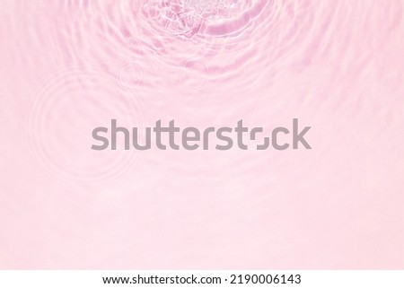 Closeup of pink water surface texture with splashes and bubbles. Abstract summer nature background.