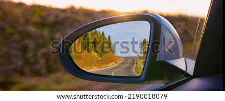 The view of the mountains in the car's rearview mirror. Travel by personal car, concept. Royalty-Free Stock Photo #2190018079