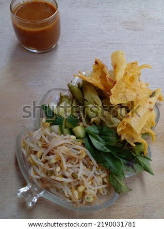Pecel. In the form of several vegetables in the form of cabbage, sprouts, cucumber, turi flower and basil mixed with peanut sauce and remepyek. Boiled vegetables are placed on a plate. Indonesian food
