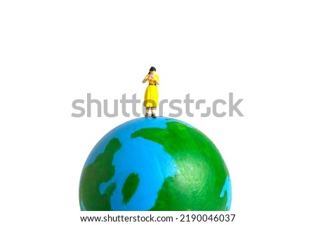 Miniature people toy figure photography. International or National reading day. A girl student standing above earth globe while read a book, isolated on white background. Image photo