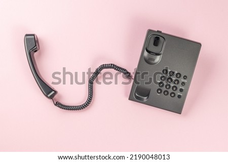 Gray landline phone on a pink background. The concept of telephone communication. Flat lay. Royalty-Free Stock Photo #2190048013