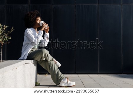 pretty young woman with coffee outdoors