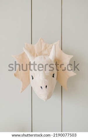 Rhinoceros or dinosaur on the wall. Stylish Scandinavian children's room with a decorated wooden wall.