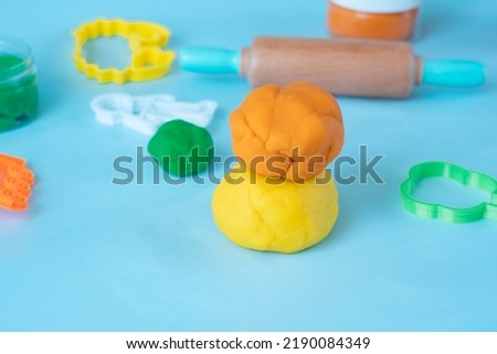 Homemade modeling clay tools kit on blue background. 
