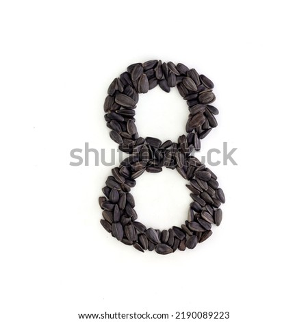 Number 8 made from sunflower seeds. Alphabet made from sunflower seeds. White background