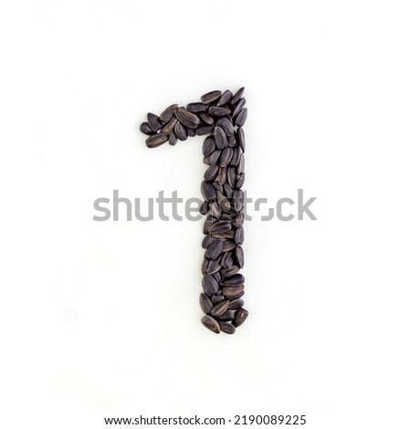 Number 1 made from sunflower seeds. Alphabet made from sunflower seeds. White background Royalty-Free Stock Photo #2190089225