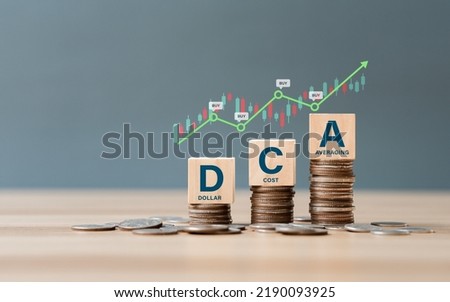 DCA word on a wooden cube on coins in idea Dollar Cost Averaging investment strategy, Saving stock or savings on a monthly, quarterly basis.