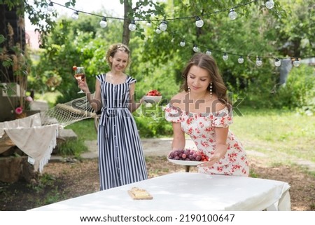 girlfriends set the table for a friendly garden party on a summer day. female friends enjoying a holiday outdoors
