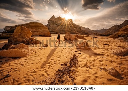 Tourist woman walking on the wild sandy beach, traveling in Oman, Arabia Royalty-Free Stock Photo #2190118487