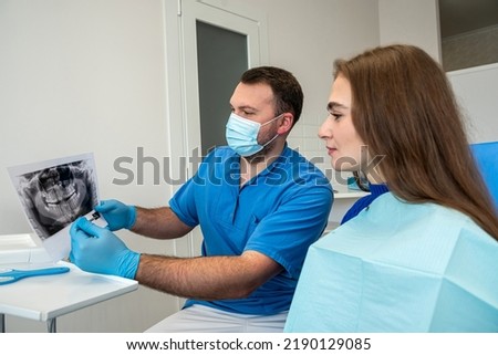 a young patient in dentistry looks at a freshly taken picture of his teeth for further treatment. Dental treatment concept