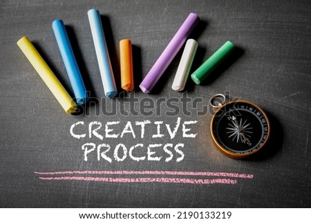 CREATIVE PROCESS. Compass and colored pieces of chalk on a blackboard.